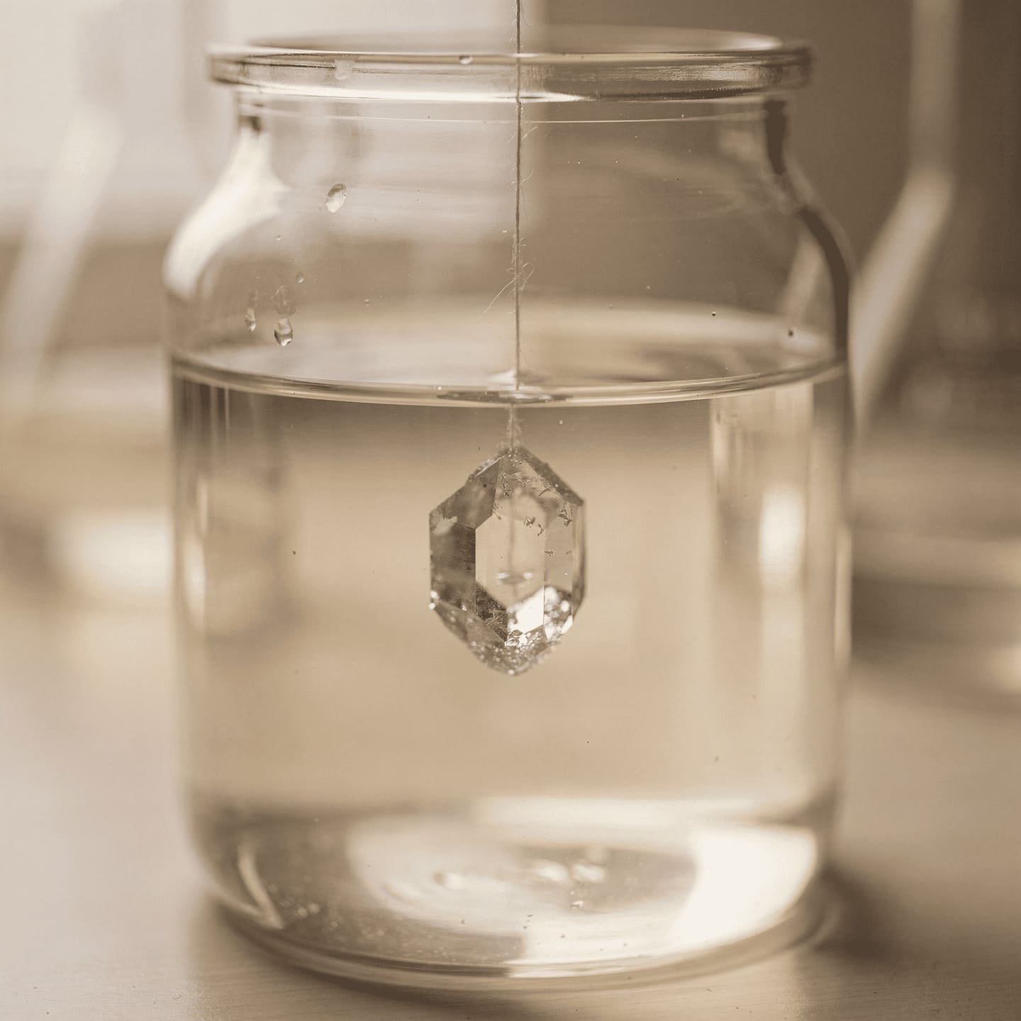 seed crystal hanging on nylon thread in supersaturated solution jar